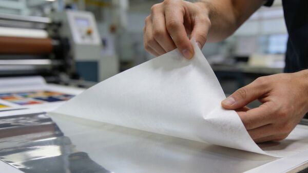 Le papier antiadhésif siliconé BRANOperl (Release Liner) se détache de manière contrôlée et sans laisser de résidus d'un film adhésif industriel. BRANOperl : papier siliconé destiné aux imprimeries, qui est décollé à la main dans un environnement de production industriel.