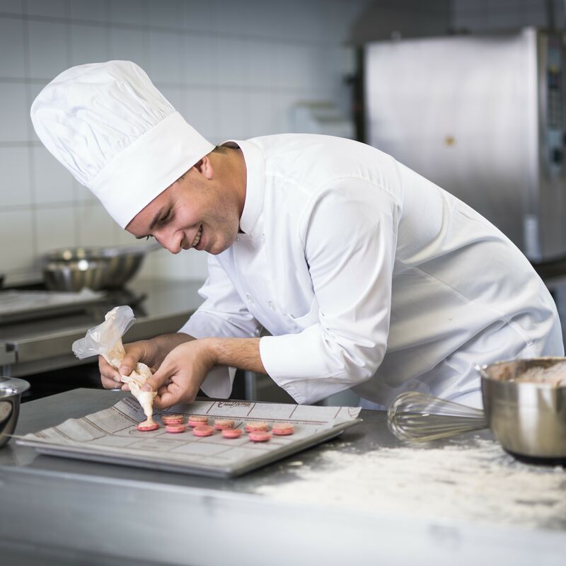 Konditor produziert Macarons auf Blechrein Papier