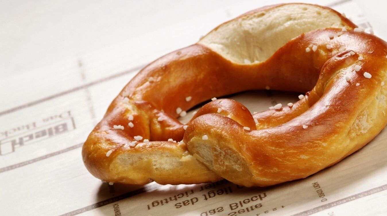 Pretzel on a baking tray lined with baking paper Freshly baked pretzel on Blechrein baking release paper with a slightly glossy, golden-brown surface.