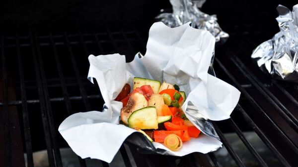 Papier d'aluminium pour la cuisson au barbecue et respectueux de l'environnement Légumes grillés sur la plaque Blechrein BBQ Pro, posée sur une grille de barbecue